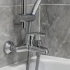 A close-up of a chrome bathtub faucet and shower head mounted on a gray tiled wall above a white bathtub. Podgląd zdjęcia produktu