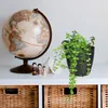 A globe, a potted plant, and wooden peg dolls are displayed on a shelf above woven baskets. Produktbild-Vorschau