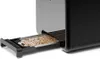 A close-up view of a toaster's crumb tray, which is extended and filled with crumbs. Produktbild-Vorschau