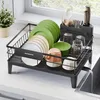 A dish rack filled with dishes and bowls on a kitchen counter next to a sink. Produktbild-Vorschau