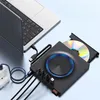 A black external Blu-ray drive is connected to a laptop and powered by a wall adapter. A CD is inserted into the drive. Produktbild-Vorschau