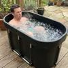 A man is sitting in an ice bath outdoors on a wooden deck. Anteprima dell’immagine prodotto