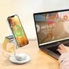 A desk setup with a laptop, a wireless charging stand for a phone, smartwatch, and earbuds. Produktbild-Vorschau