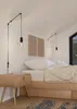 A bedroom scene with a bed, nightstand, and hanging lamps. Náhľad obrázku produktu