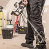 A person is holding a power mixer in a construction or renovation setting. Náhled obrázku produktu
