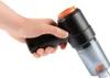 A hand holding a black and orange handheld vacuum cleaner against a white background. Produktbild-Vorschau