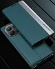A teal smartphone case with a silver accent strip is shown in a studio setting with a dark, reflective background. Produktbild-Vorschau
