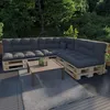 An outdoor seating area with a sectional sofa made of pallets and dark gray cushions, a coffee table, and a rug on a deck, surrounded by trees and greenery. Voir les images du produit