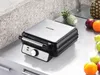 A waffle maker is shown on a kitchen counter with fruits in the background. Podgląd zdjęcia produktu