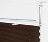 Close-up of the top mechanism of a brown pleated blind attached to a white window frame. Produktbild-Vorschau