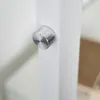 A close-up shot of a silver knob on a white pole, likely part of a lamp or other fixture. Produktbild-Vorschau