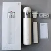 A flat lay of a white Xiaomi handheld vacuum cleaner and its accessories, along with its packaging, on a gray background. Náhled obrázku produktu