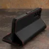 A black leather phone case with red stitching is shown in a studio setting. Anteprima dell’immagine prodotto
