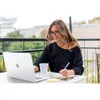 A woman is working on her laptop on a balcony. Náhľad obrázku produktu