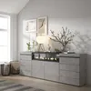 A modern living room with a gray sideboard featuring an electric fireplace, decorative items, and artwork on the wall. Produktbild-Vorschau