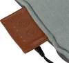 A close-up of a brown leather tag attached to a blue fabric product, with a black cable plugged into the tag. Produktbild-Vorschau
