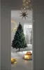 A Christmas tree is set up in a doorway, decorated with lights and a star. Produktbild-Vorschau