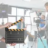 A film set with a clapperboard in the foreground and a film crew in the background. Náhled obrázku produktu