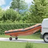 An orange inflatable boat is being transported on a trailer attached to a white van, outdoors with trees and bushes in the background. Anteprima dell’immagine prodotto