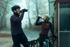 Two cyclists taking a break and drinking from their water bottles on a foggy day. Produktbild-Vorschau