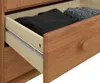 A close-up view of an open wooden drawer with clothes inside. Produktbild-Vorschau