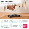 A clothes drying rack with clothes on it, placed on a rug in front of a wall. Produktbild-Vorschau