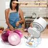 A woman is chopping vegetables in a kitchen, with a food chopper and onions in the foreground. Produktbild-Vorschau