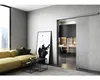 A modern living room with a yellow sofa, abstract art, and a view into a kitchen through a sliding glass door. Náhled obrázku produktu