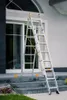 A multi-purpose ladder is set up on outdoor stairs in front of a large window. Produktbild-Vorschau