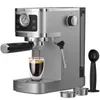 A silver espresso machine with a glass of coffee being brewed, placed on a white background. Accessories like scoops and filter holders are also visible. Náhľad obrázku produktu