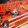 A close-up shot of a retro arcade game cabinet, focusing on the lock mechanism and some of the artwork. Produktbild-Vorschau