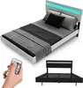 A modern bed with a white frame and a grey and black bedspread, featuring an LED light strip in the headboard and a remote control in a person's hand. A separate image below shows the black metal bed frame. Náhľad obrázku produktu
