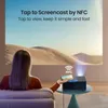 A woman is using a smartphone to screencast to a projector in a living room setting. Náhled obrázku produktu