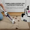 A person is using a cordless stain remover on a carpet with pet paw prints and dirt. Podgląd zdjęcia produktu