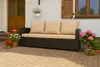 A brown rattan sofa with beige cushions is placed on a paved patio next to potted plants. Produktbild-Vorschau