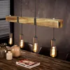 A vintage-style wooden beam pendant light with Edison bulbs hangs over a wooden dining table with decorative vases and a book. Anteprima dell’immagine prodotto