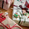 Christmas gifts wrapped in decorative paper with LEGO gingerbread figures attached. Produktbild-Vorschau