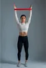 A woman is performing an exercise with a resistance band. Produktbild-Vorschau