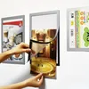 Hands are shown changing a picture in a magnetic frame mounted on a wall, with other frames visible. Náhľad obrázku produktu