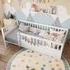 A child's bedroom with a white wooden bed, decorated with a mountain mural and a polka dot rug. Anteprima dell’immagine prodotto