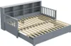 A gray wooden daybed with a pull-out trundle bed and a bookshelf headboard. Anteprima dell’immagine prodotto