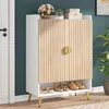 A shoe cabinet with a wooden slatted door and gold handle, placed in an entryway next to a white door. Produktbild-Vorschau