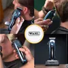 A collage of images showing a Wahl hair clipper being used by a barber and a product shot of the clipper on its stand. Produktbild-Vorschau