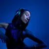 A person wearing headphones in a blue lit environment. Náhľad obrázku produktu