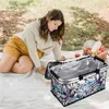 A woman is having a picnic outdoors with a picnic basket. Náhled obrázku produktu