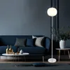 A modern living room with a blue sofa, coffee table, and a floor lamp. Produktbild-Vorschau