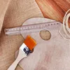 A painting palette, brush, ruler, and twine are laid out on a burlap and wooden surface. Náhled obrázku produktu