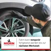 A person in a black cap and gloves is inspecting a car tire. Náhled obrázku produktu