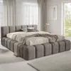 A modern bedroom with a large upholstered bed. Voir les images du produit