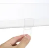A hand is shown holding a clear plastic loop attached to a white roller blind mechanism. Produktbild-Vorschau